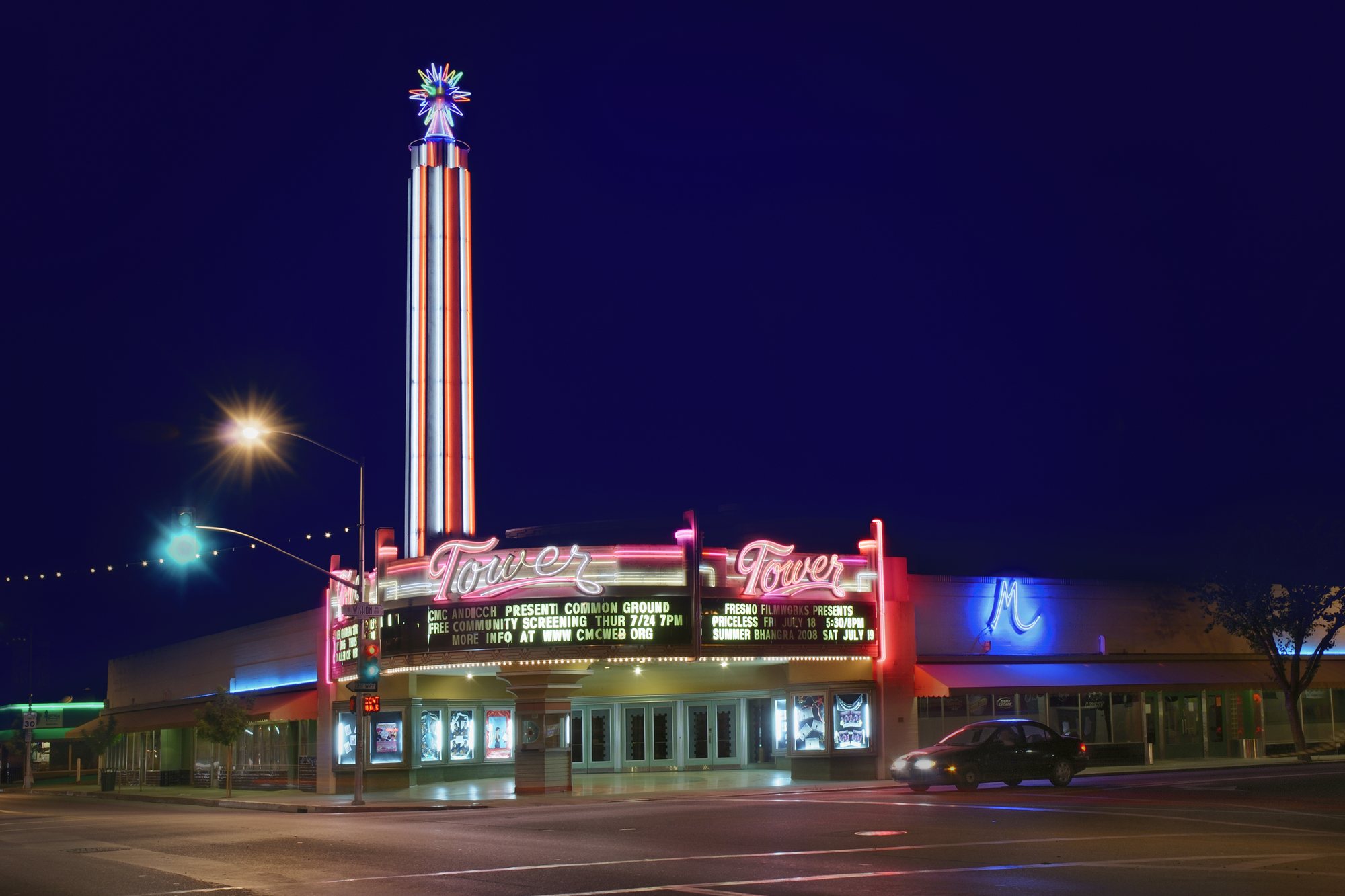 The Tower Theatre in Fresno’s Tower District at night, its neon marquee and Streamline Moderne tower lit